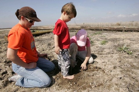 800px-A_young_boy_helps_his_sister_mother_and_the_girl_scouts_plant_trees