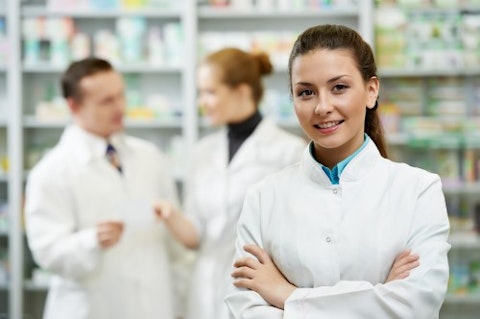 cheerful pharmacist chemist woman standing in pharmacy drugstore