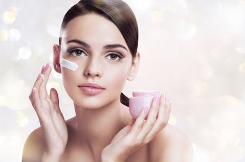 Girl applying creme, beautiful young girl