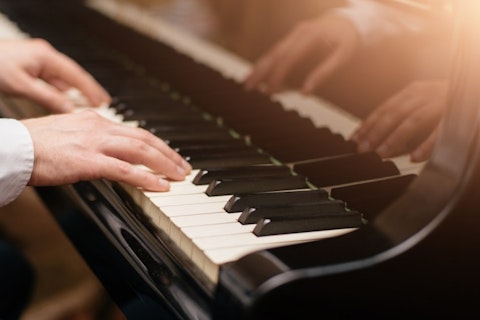 shutterstock_562181437 Close-up of a music performer's hand playing the piano, concert, art, music, sound, playing, hands, keyboard, classic, instrument, pianist