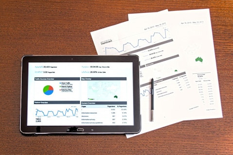 graphs in a tablet and papers on the side