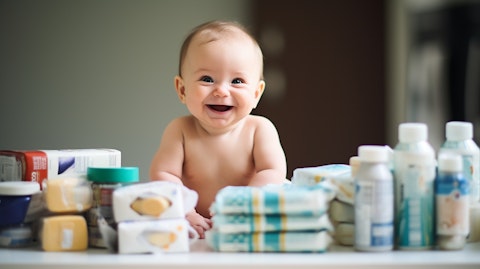 A smiling baby with an array of baby care products in the foreground.