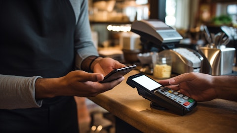 A consumer in a cafe paying for goods using a mobile payment app.