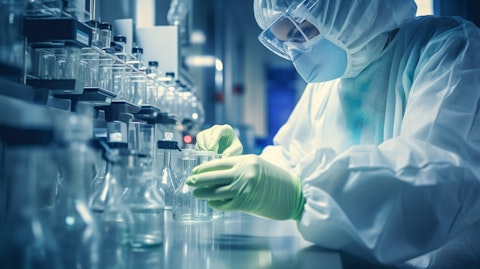 A medical technician wearing protective gloves and a mask mixing a biopharmaceutical solution.