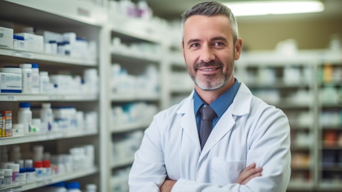 A successful pharmacist in front of shelves of drugs in a community-based oncology pharmacy.