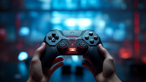 A close-up of a hand holding a game controller, demonstrating the interactive entertainment of the company.
