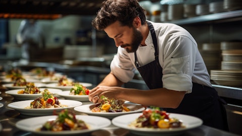 A chef plating up a wide variety of dishes for a restaurant chain.