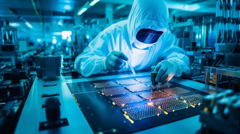 A technician in a clean room working on a semiconductor device, illuminated by the machines.