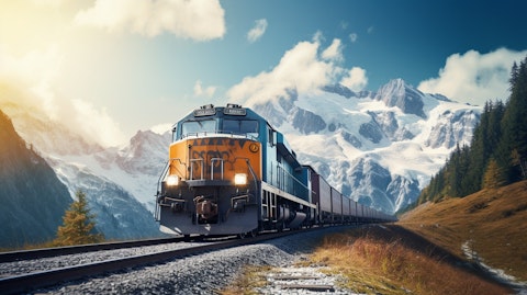 A freight train making its way through a majestic mountain range, snow-capped peaks in the distance.