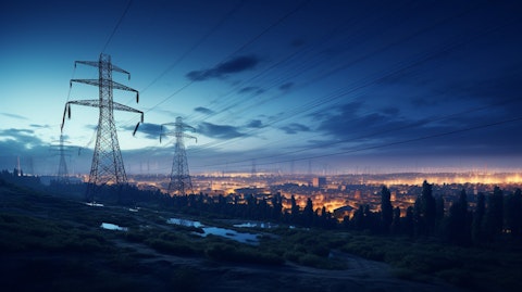 Brightly-lit nighttime view of an electricity power grid with distribution lines and transmission substations.