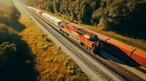 A bird's eye view of a long freight train rumbling along the tracks.