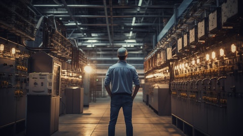 A technician standing in the middle of a power station, inspecting a power distribution system.