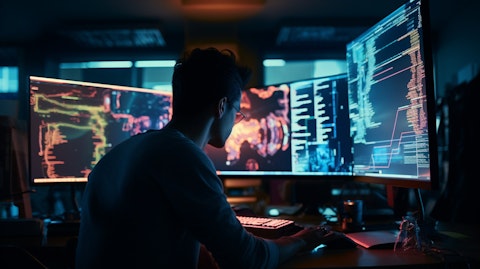 A software developer in front of a monitor, coding to build the latest internet content & information.