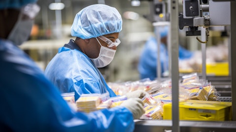 A worker in a production facility packaging arbitrary food products, reflecting the company's commitment to comprehensive production standards.