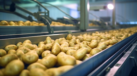 Potatoes being sorted on a conveyor belt in a modern packing facility.