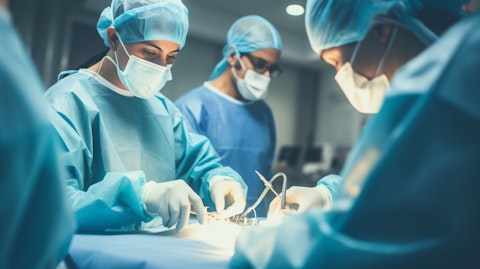 A medical team wearing surgical masks and gloves carrying out a hip or knee joint replacement surgery with the help of surgical navigation systems.