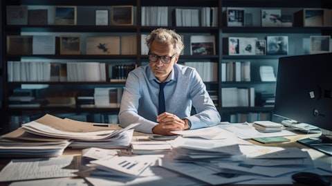 An executive at a desk, surrounded by financial documents and a laptop.
