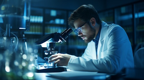 A laboratory technician in a high-tech lab, examining a specimen under a microscope.