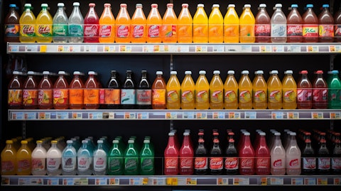 A shelf filled with a variety of bottles of energy drinks, juices, and sodas in a convenience store.