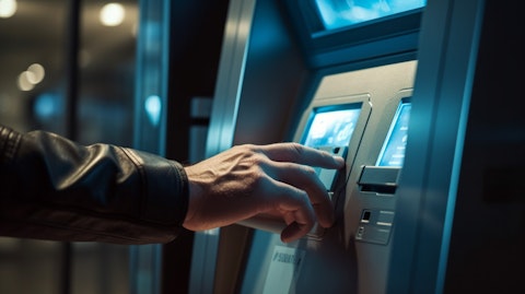 A closeup view of a hand inserting a credit card into an ATM machine.