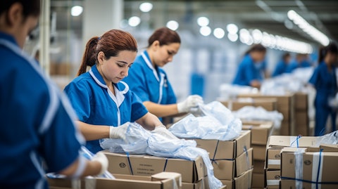 A team of factory workers packaging items in a modern factory.