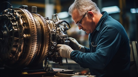 An aeronautics engineer inspecting a model aircraft engine in a factory setting.