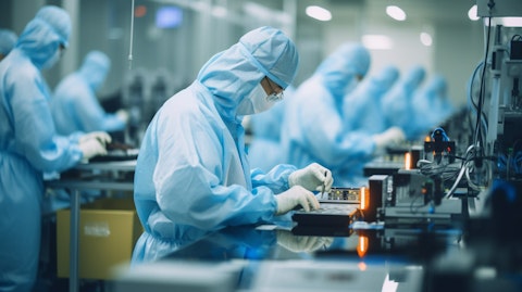 Workers assembling precision and science technology components in a factory.