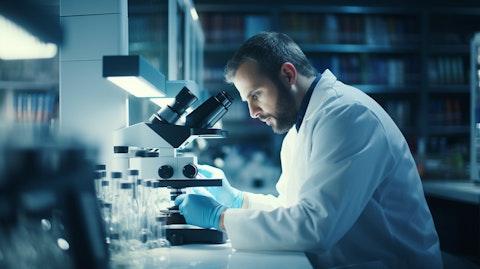 A researcher studying genetic medicines under a microscope in a biopharmaceutical laboratory.