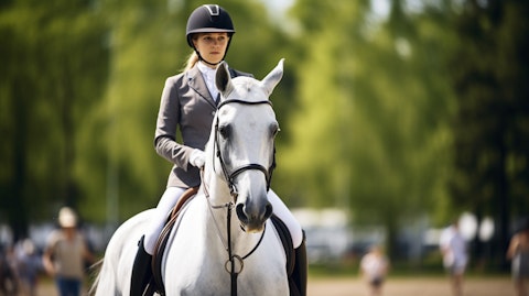 An equestrian rider proudly leading a horse around a competition course.