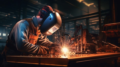 A welder in a hardhat soldering steel plates to a blueprint plan.