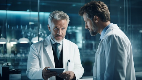 A medical professional in a lab coat discussing with a colleague.