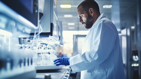 A technician in a lab coat monitoring a chromatography machine.