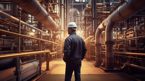 A refinery manager walking through an array of pipes and pumping systems, recognizing the company's vast refining power.