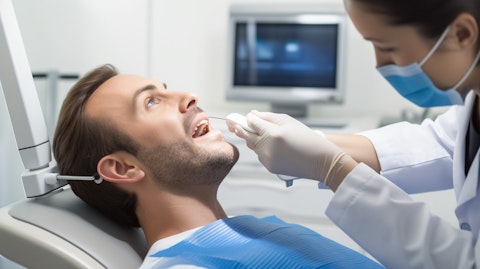 An orthodontist examining a patient's teeth with a intraoral scanner, demonstrating the precision of the company's technology.