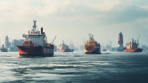 A fleet of offshore supply vessels and tugs carrying materials to an oilrig in the distance.