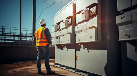A workman standing next to a newly constructed wall, showcasing the company's electrical enclosures.