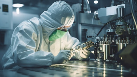 A technician in a specialized cleanroom suit, preparing a microcontamination control pipeline.