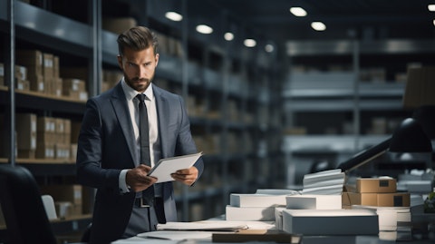 An executive in a suit working in a modern office surrounded by the products the company sells.