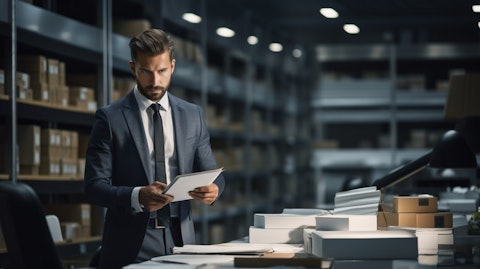 An executive in a suit working in a modern office surrounded by the products the company sells.