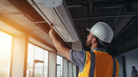 An engineer wearing a hardhat inspecting a newly-installed air conditioner system.