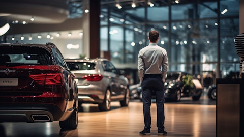 A customer in a store, examining a new vehicle on the showroom floor.