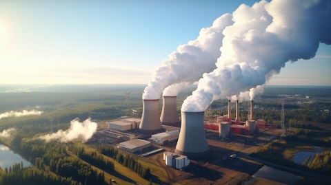 Aerial view of a power plant with smoke emitting from its cooling towers.