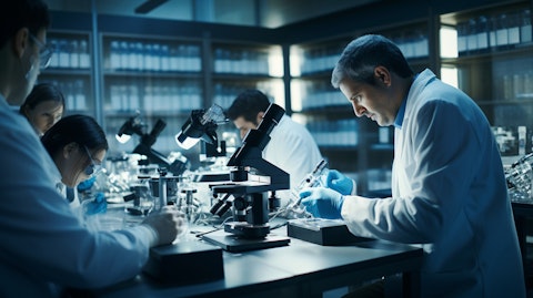 A research team in a laboratory peering through microscopes at a biologic product.