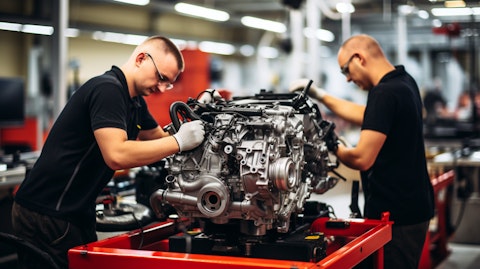 Workers assembling a state-of-the-art engine in a modern auto factory.