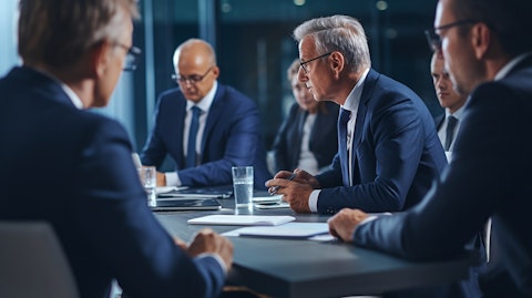 An executive in a suit and tie at a meeting discussing asset management strategies.
