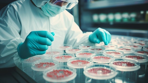 A scientist in a lab coat working with petri dishes containing biopharmaceutical drugs.