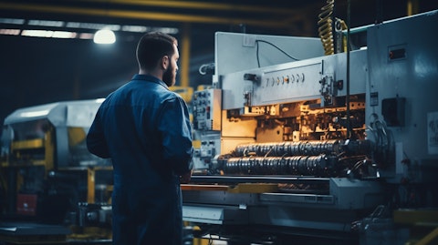 A technician in a factory setting next to an industrial automation machine.
