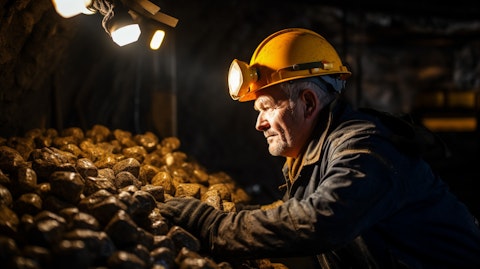 A miner examining yellow gold ore in a mine shaft, symbolizing the company's exploration process.