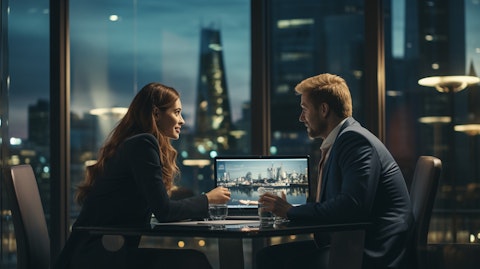 A woman and man in formal attire in a meeting room discussing the latest enterprise solutions technology from the company.