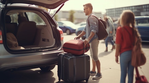 A close up shot of a family loading their luggage into a car rental vehicle.
